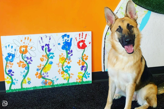 Dogtopia hond naast poot-geschilderde kunst